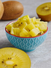 Golden kiwifruit chopped chunks in a bowl. Fresh kiwi fruit salad snack.