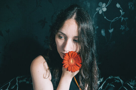Portrait Of Young Woman Holding Orange Flowers