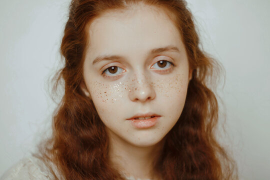 Portrait of young woman with glitter freckle and red hair