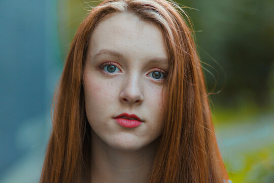 Portrait of young woman with red hair and blue eyes