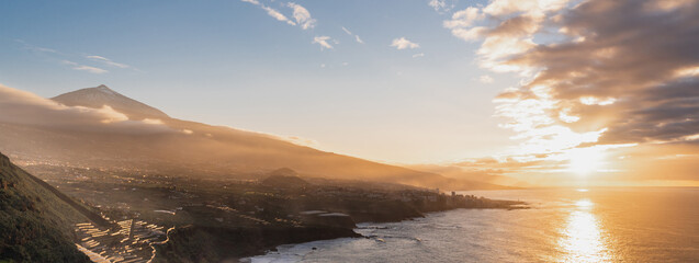 Horizontal banner or header of Amazing volcanic landscape with ocean coast during sunset. Teide...