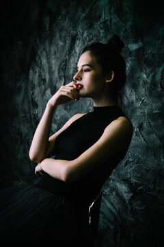 Side view of woman in dark top with red lipsticks