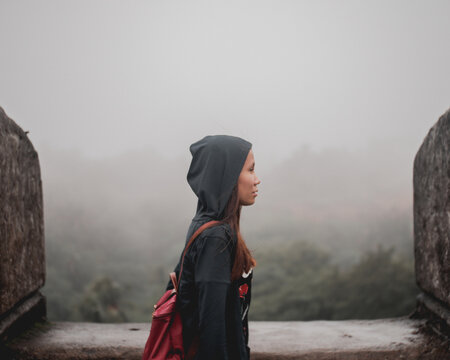 Side view of woman wearing hoodie standing in the rain outdoor