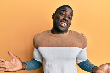 Young african american man wearing casual clothes clueless and confused expression with arms and...