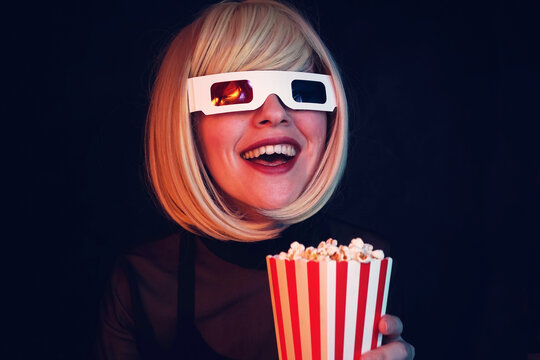 Smiling woman wearing 3D glasses and holding a popcorn