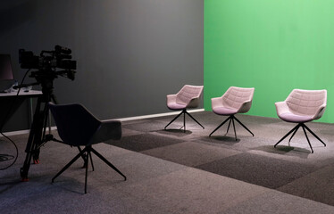 Three chairs against green backdrop at a studio