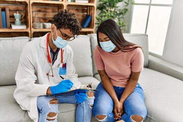 Fototapeta premium Young doctor man reading patient checklist report sitting on the sofa at the clinic.