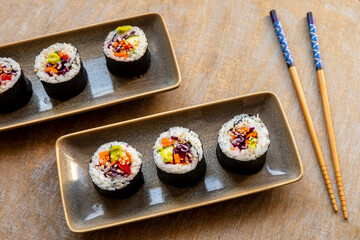 Vegan Futomaki (thick sushi rolls) with zucchini, celery stalks, carrot, red cabbage and red bell pepper.