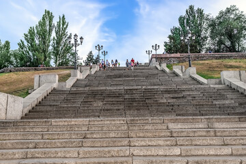 People go down the stairs on Flotsky Boulevard in Mykolaiv, Ukraine - view from below. Walking place for tourists in the Ukrainian town on a summer evening