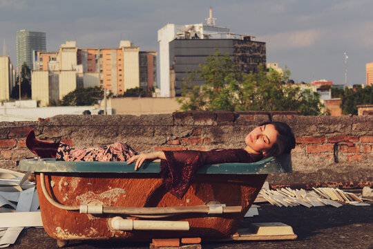 Woman laying in bath tub outdoor