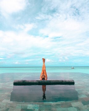 Woman lying on bench in swimming pool