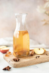chilled apple tea with honey and cinnamon in a glass bottle, close-up