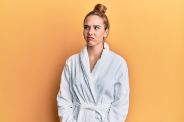 Young blonde woman wearing bathrobe skeptic and nervous, frowning upset because of problem. negative person. - obrazy, fototapety, plakaty
