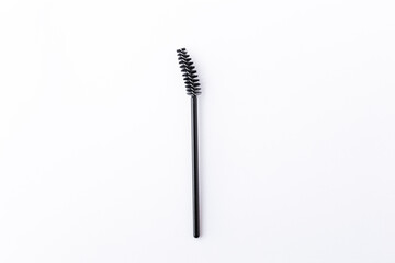 one short small black eyelash brush isolated on white background close-up top view