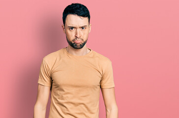 Hispanic man with beard wearing casual t shirt depressed and worry for distress, crying angry and afraid. sad expression.