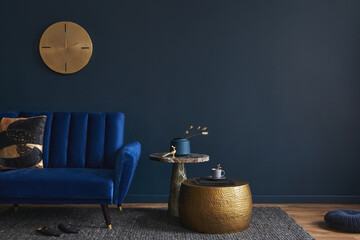 Modern living room interior composition with velvet blue sofa, design side table and elegant home decor. Dark blue wallpaper. Template. Copy space.