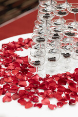 tapioca pearls in champagne glass pyramid tower decorated with rose petals on white cloth table