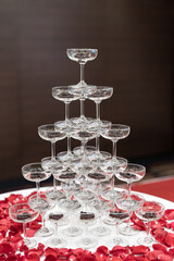tapioca pearls in champagne glass pyramid tower decorated with rose petals on white cloth table
