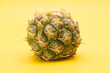 whole pineapple isolated on yellow background, healthy rich fruit