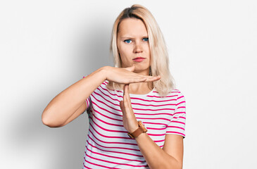 Young caucasian woman wearing casual clothes doing time out gesture with hands, frustrated and...