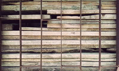 Plank pile behind a steel cage, retro vintage style