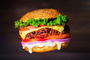 Close-up of delicious homemade burgers on a wooden table on a dark background beef hamburger...