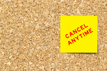 Yellow note paper with word cancel anytime on cork board background with copy space