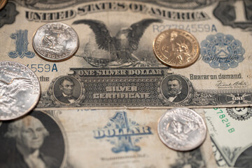 Half Dollar and Dollar coins on historic 1 US Dollar banknotes