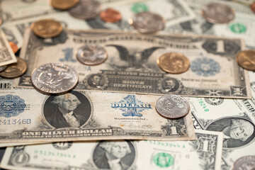 Half Dollar and Dollar coins on historic 1 US Dollar banknotes