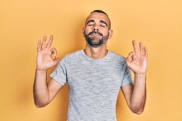 Young hispanic man wearing casual clothes relax and smiling with eyes closed doing meditation gesture with fingers. yoga concept.