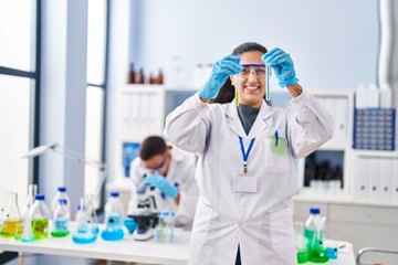 Man and woman wearing scientist uniform hoding test tubes at laboratory