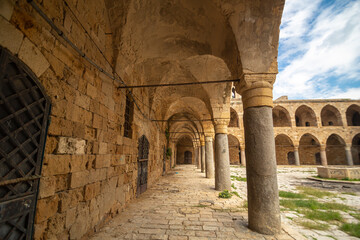 Medieval square building with a courtyard and many arches