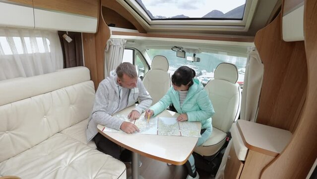 Couples in RV Camper looking at the local map for the trip.