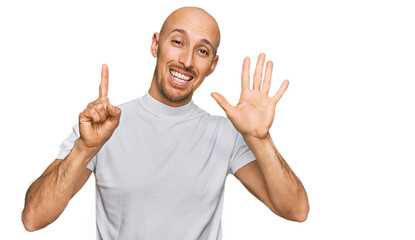 Bald man with beard wearing casual white t shirt showing and pointing up with fingers number six while smiling confident and happy.