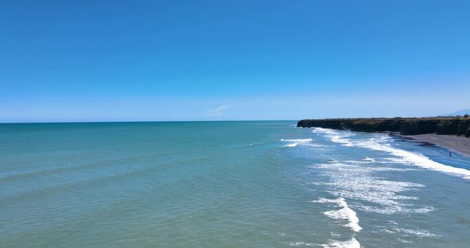 Fly high over rolling turquoise sea and surf at Patea Beach - New Zealand