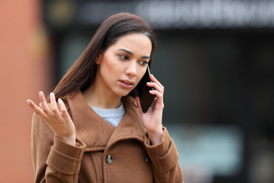 Angry woman in the street talking on phone
