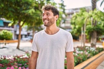Young hispanic man smiling confident walking at park - obrazy, fototapety, plakaty