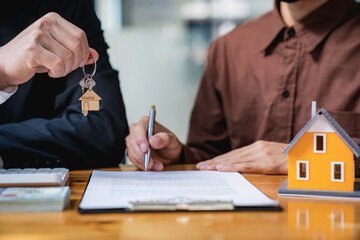 Real estate company to buy houses and land are delivering keys and houses to customers after agreeing to make a home purchase agreement and make a loan agreement. Discussion with a real estate agent