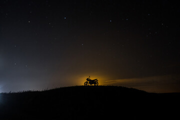 silhouette of a classic motorcycle at night in the moonlight in nature
