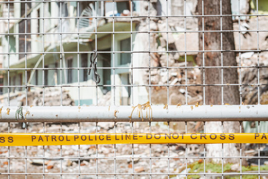Yellow tape with Police line Do not cross inscription in front of destroyed building . 