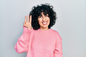 Fototapeta na wymiar Young middle east woman wearing casual clothes showing and pointing up with fingers number three while smiling confident and happy.