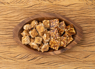Pe de moleque, typical brazilian peanut candy over wooden table. June festival food