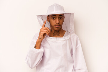 Young African American beekeeper isolated on white background pointing temple with finger, thinking, focused on a task.