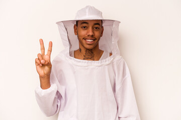 Young African American beekeeper isolated on white background showing number two with fingers.