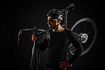 Fototapeta na wymiar male cyclist with road bicycle on black background