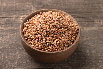 Buckwheat groats on wooden background. Healthy cereal concept.  