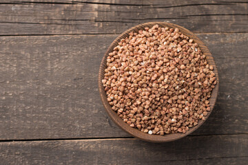 Buckwheat groats on wooden background. Healthy cereal concept.  