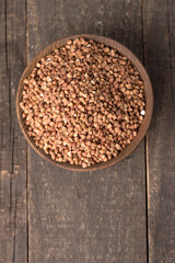 Buckwheat groats on wooden background. Healthy cereal concept.  