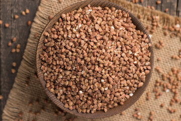 Buckwheat groats on wooden background. Healthy cereal concept.  