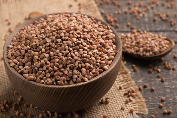 Buckwheat groats on wooden background. Healthy cereal concept.  